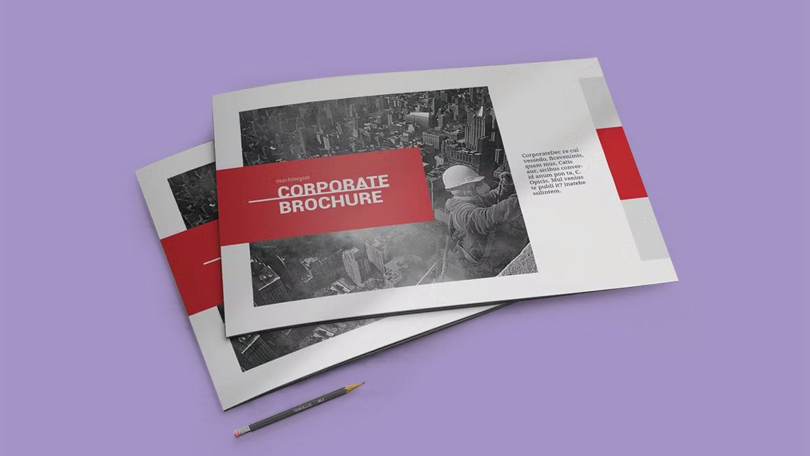 Two brochures are stacked on top of each other on a purple surface next to a pencil.