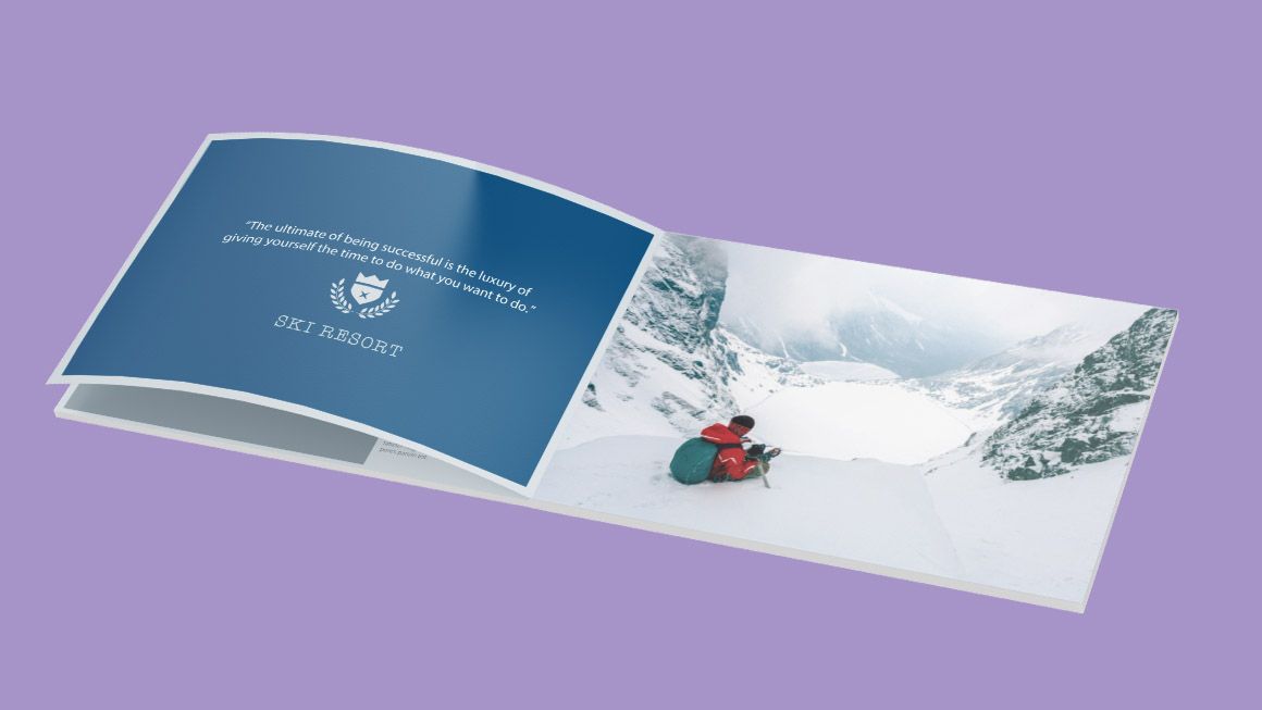 A book is open to a page with a picture of a person on a sled in the snow.