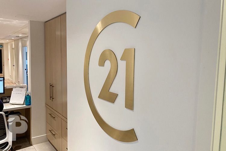 A wall with a custom cut Century 21 logo