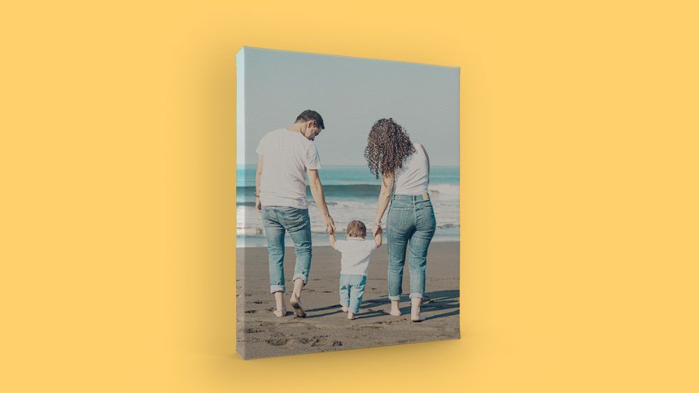 A canvas print of a family holding hands on the beach.