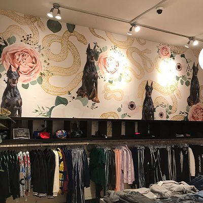 A clothing store with a mural of dogs and snakes on the wall