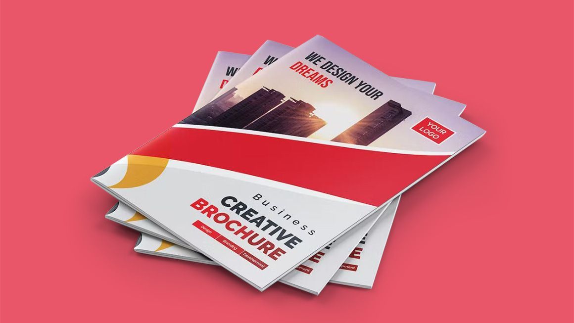Three brochures are stacked on top of each other on a pink background.