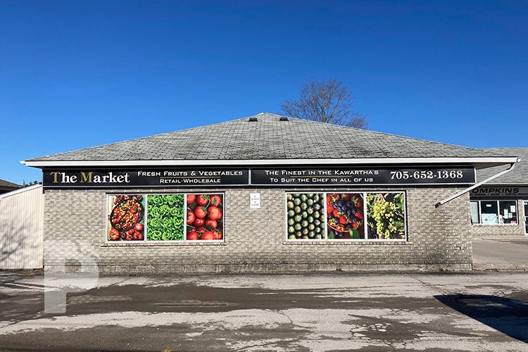 A brick building with window graphics and a sign that says
