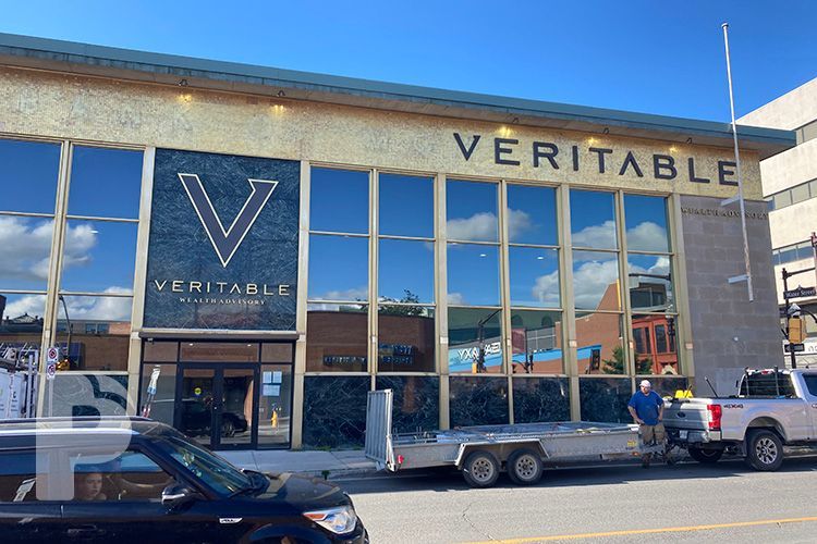 A car is parked in front of a building that says ' veritable ' on it.