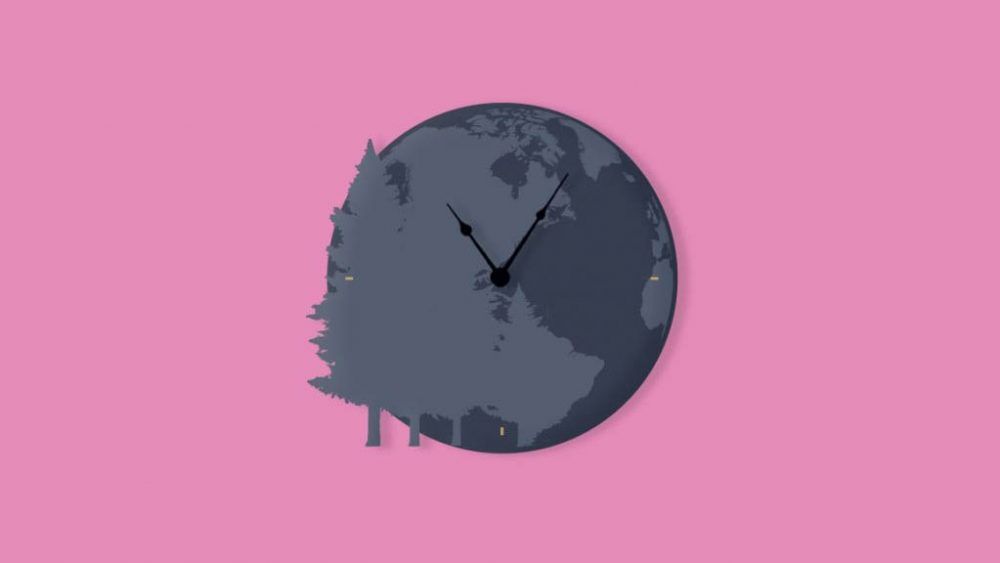 A clock with a globe on it is on a pink background.