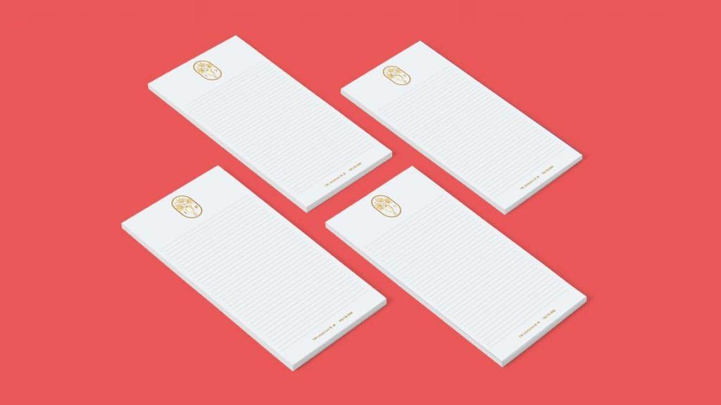 Four white envelopes are sitting on top of each other on a red background.