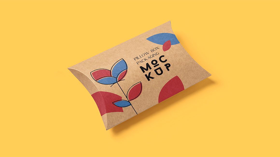 A brown pillow box with a flower on it is sitting on a yellow surface.