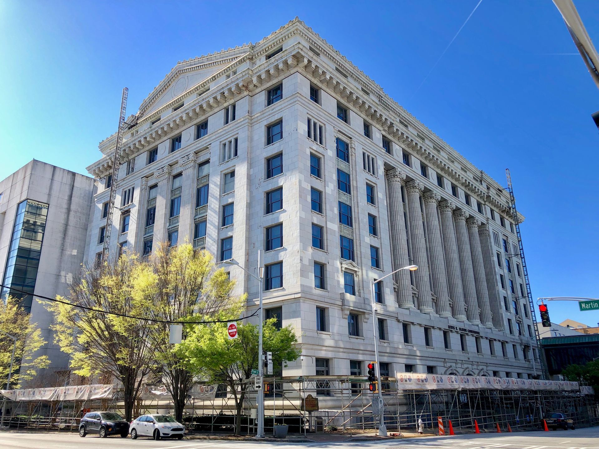 Large, white courthouse building with columns under a bright blue sky.