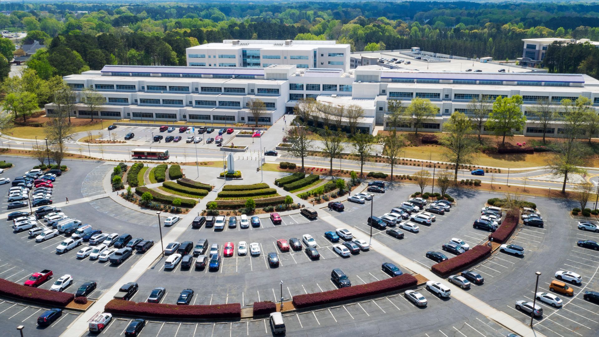 Large multi-story white building with surrounding parking lots.
