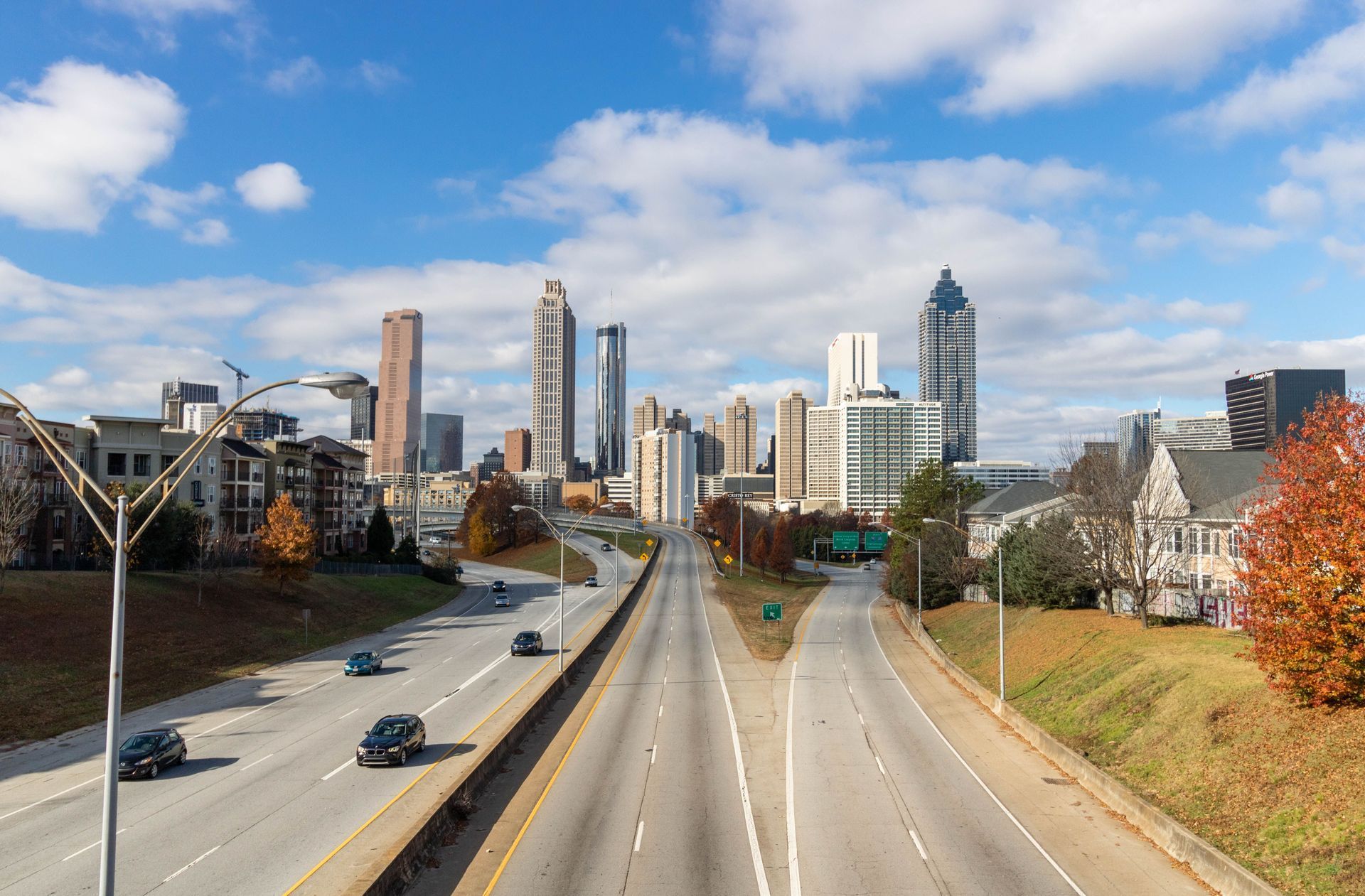 City skyline beyond a mostly empty highway under a clear sky