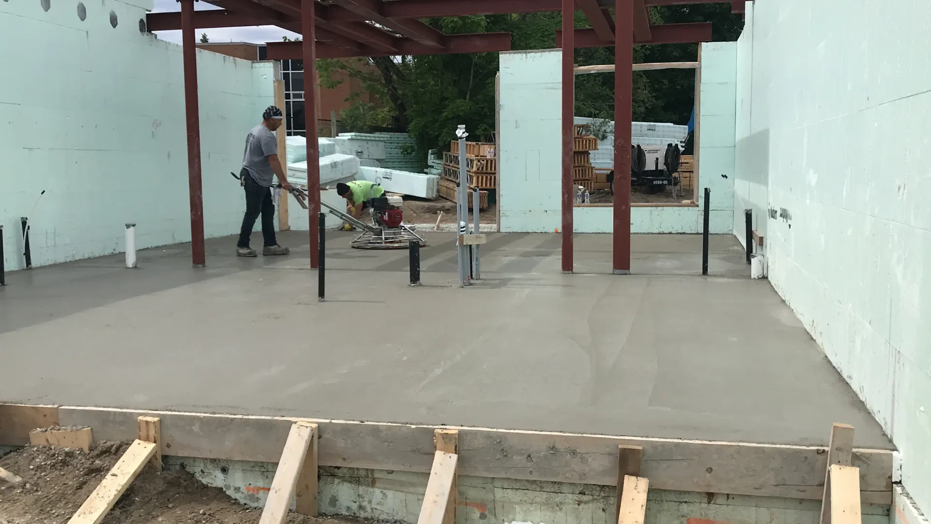 A man is shoveling concrete on a construction site.