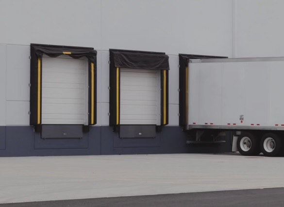 A truck is parked in front of a building with a loading dock.