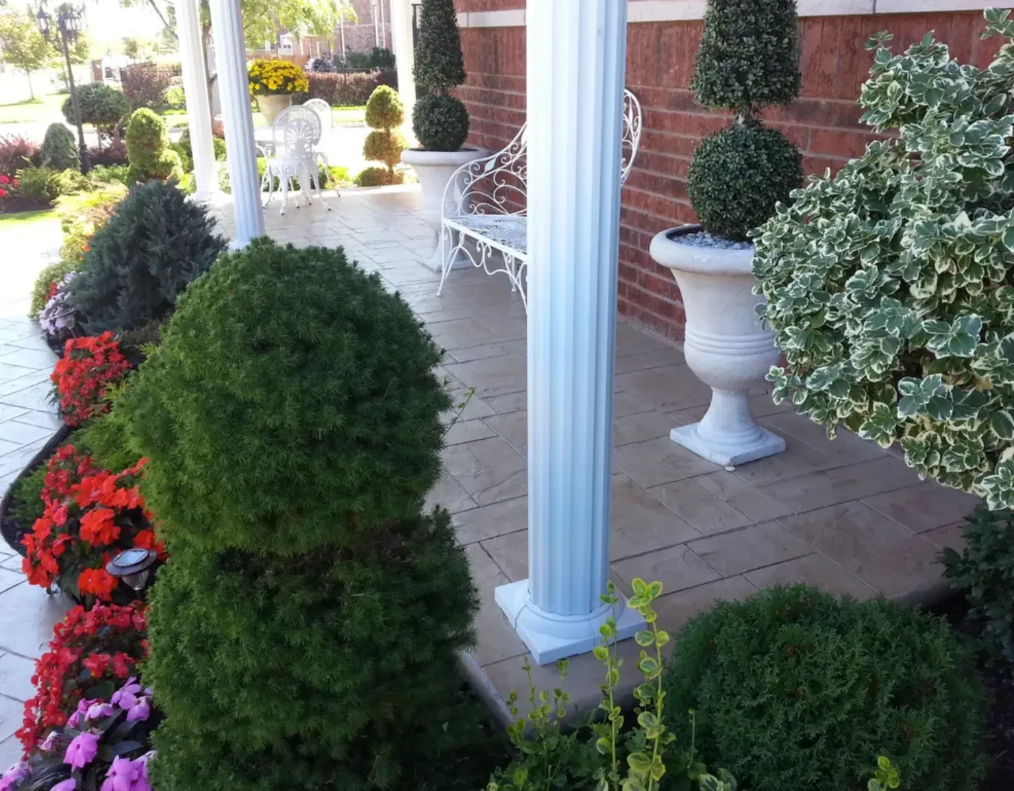A porch with lots of plants and flowers on it