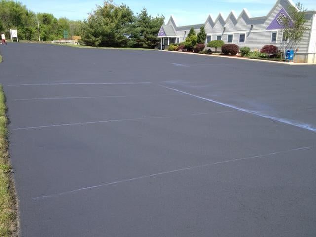 A large empty parking lot with a building in the background.