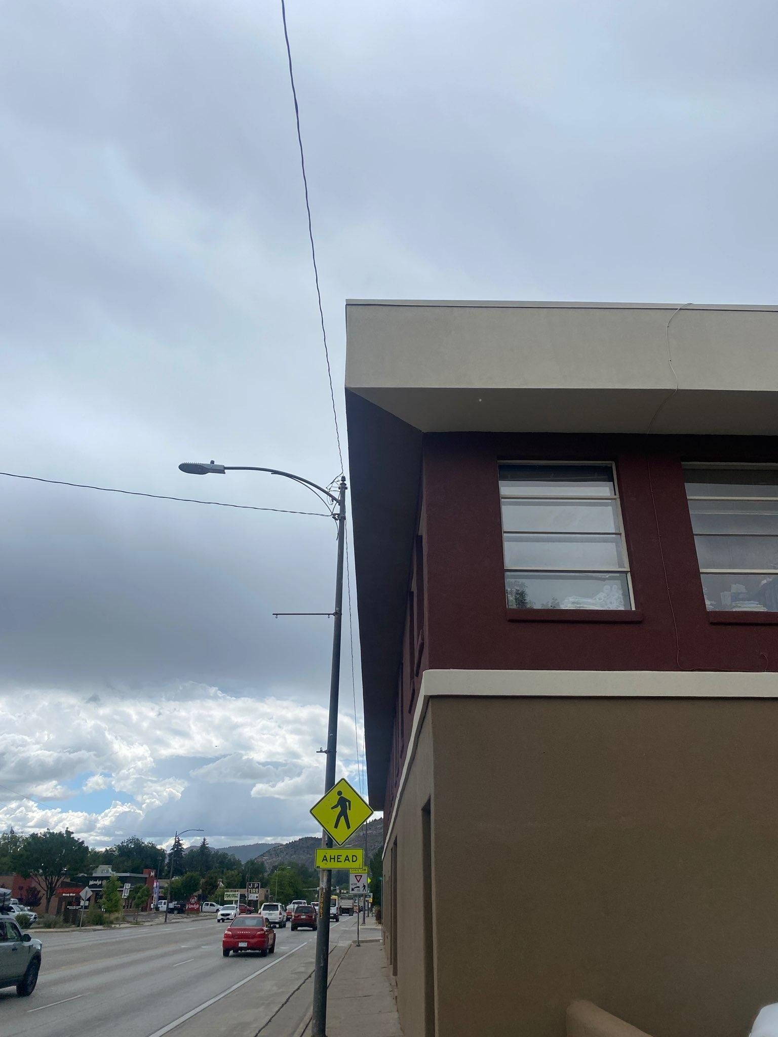 A building with a yellow sign on the side of it. Commercial exterior paint services
