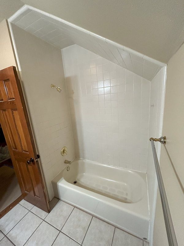 A bathroom with a bathtub and a shower.