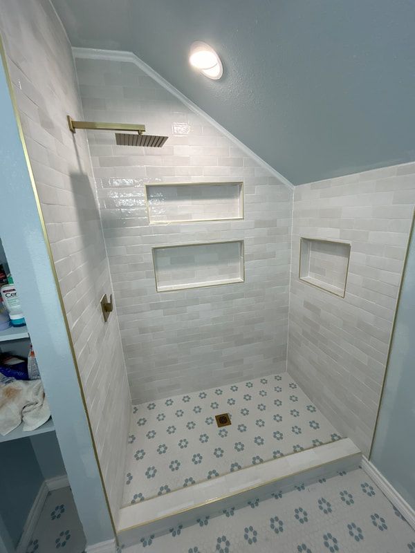 A bathroom with a walk in shower and a shower head.