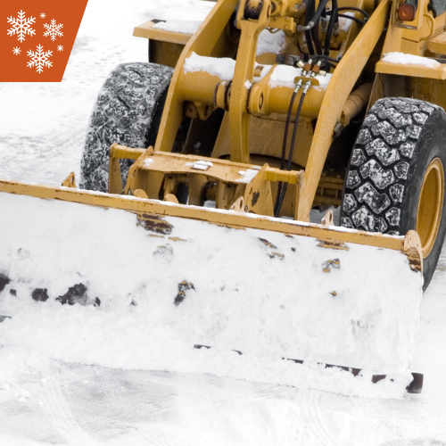 Yellow snowplow clearing snow from a road during winter.