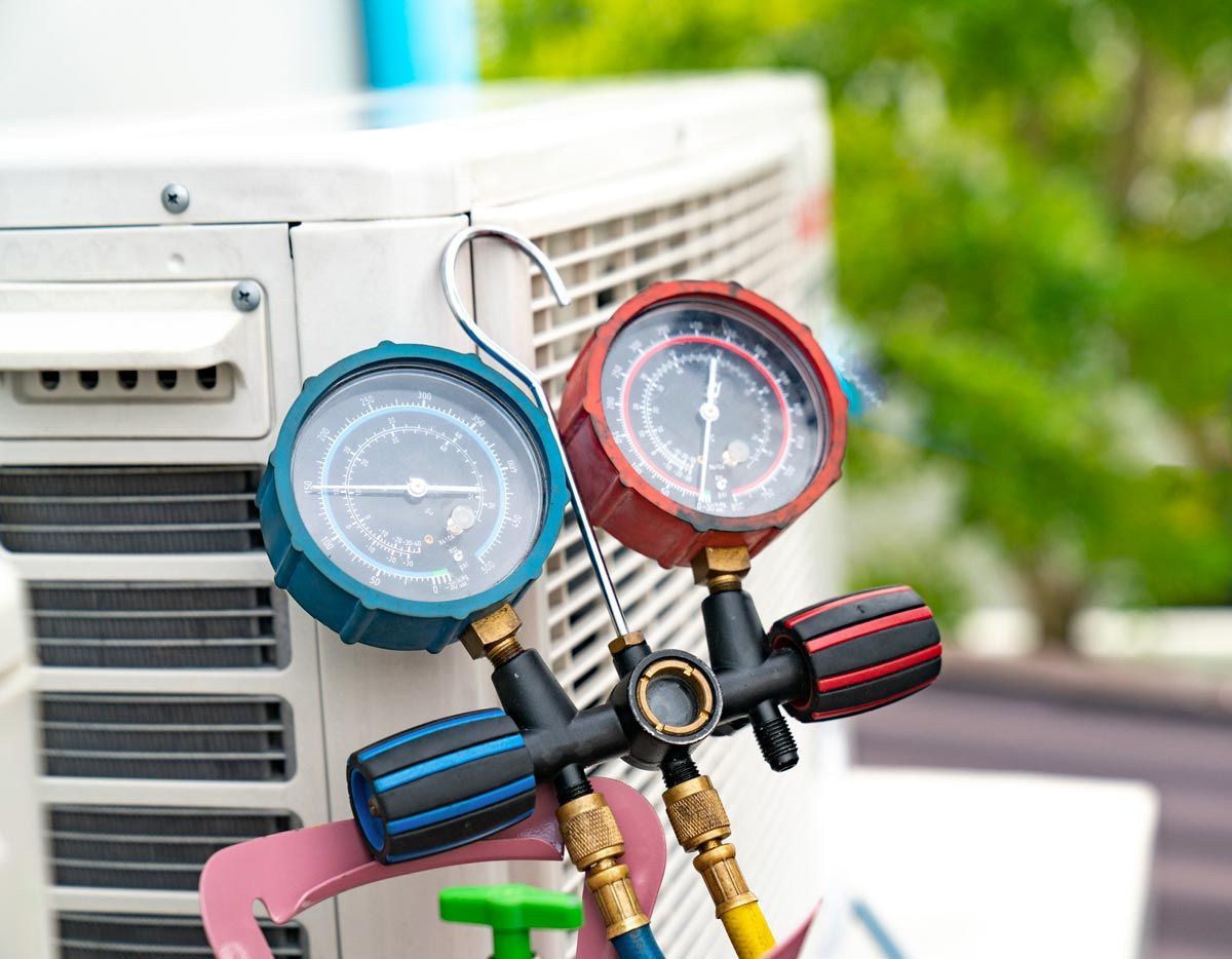 A couple of gauges sitting on top of an air conditioner.