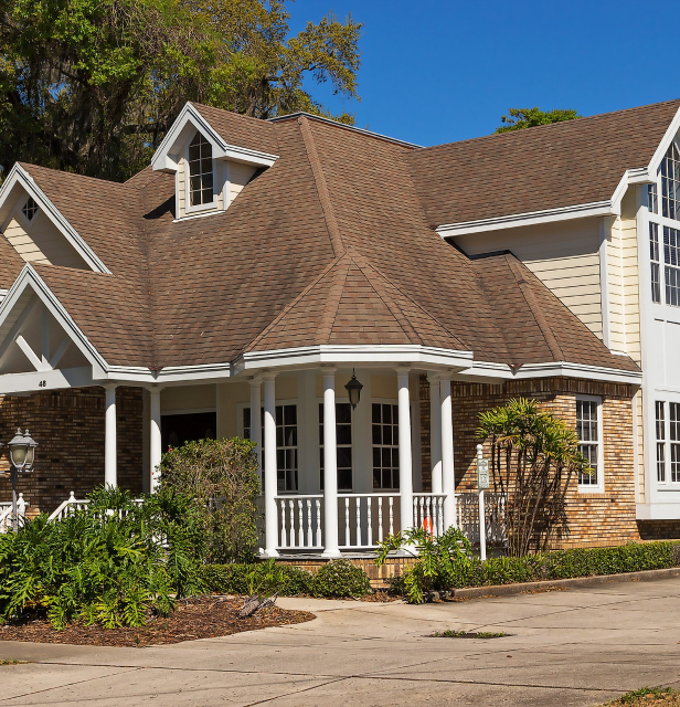 A large house with a brown roof and white trim