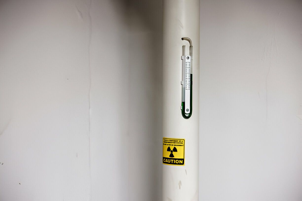 A white pipe with a yellow sticker on it that says danger