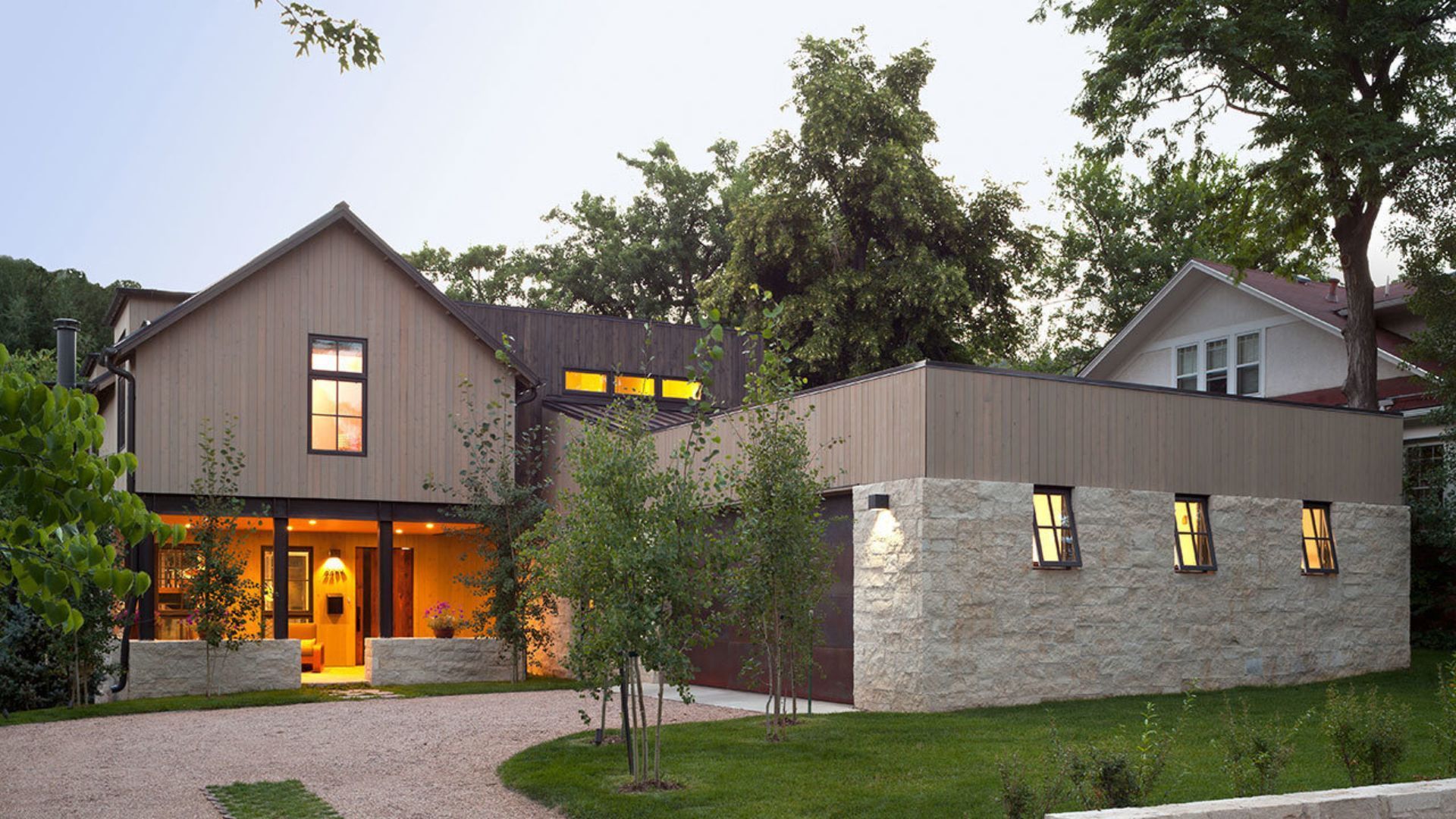 A house with a lot of windows and a gravel driveway