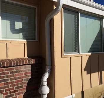 A house with a white gutter on the side of it.