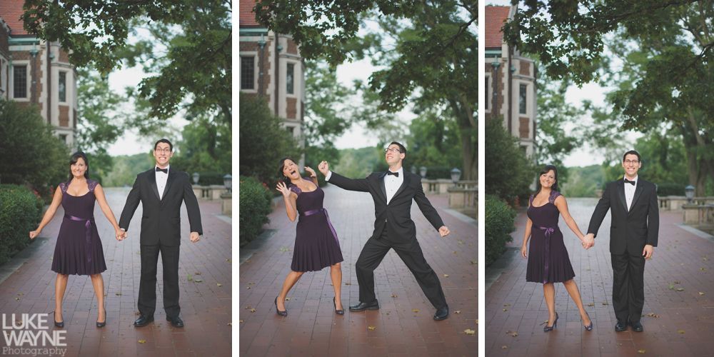 A couple in formal attire playfully posing outdoors. The woman in a purple dress, the man in a tuxedo.