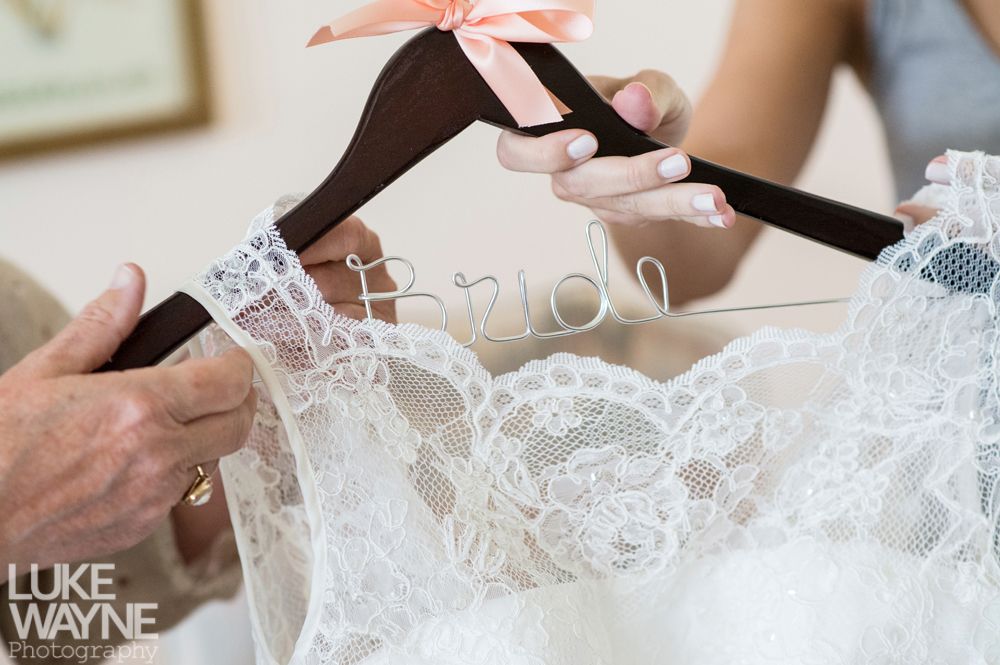 Close-up of a white lace wedding dress on a hanger with 