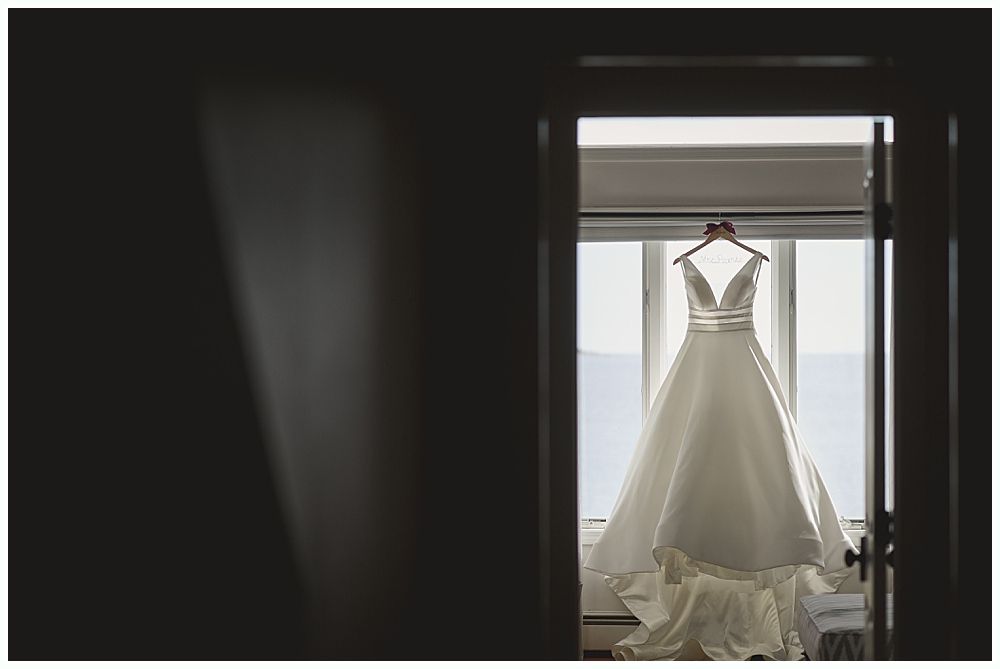 Wedding details: Earrings, veil with floral embroidery, and bouquet with dark red flowers.