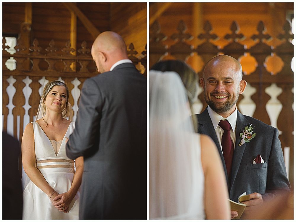 Bride and groom holding hands, smiling. She wears a white dress and veil, he wears a blue suit. Outdoors, near trees.