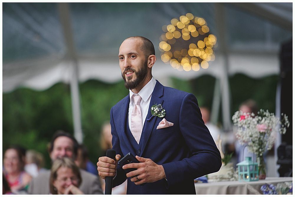 Wedding reception: couple dancing in a dark venue. Guests watch from tables.
