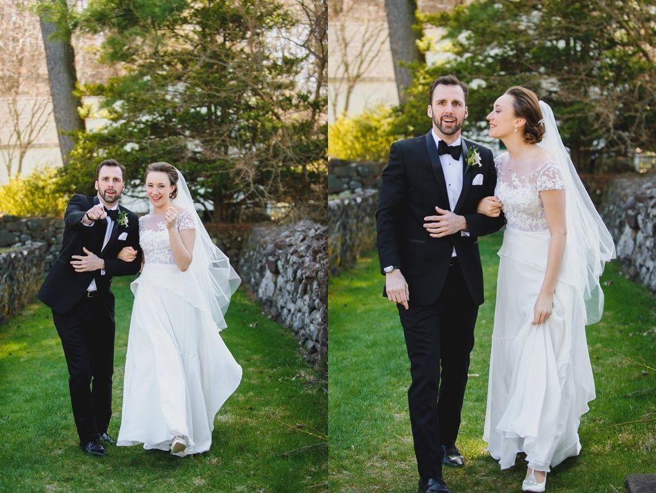 Bride with arms up, making a funny face, groom looking at his hand, cake cutting in background.