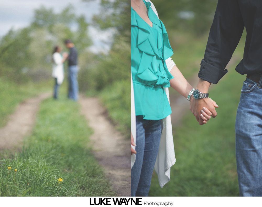 Couple holding hands, partially in focus. Blurred image of couple at a distance on a path. Green tones.