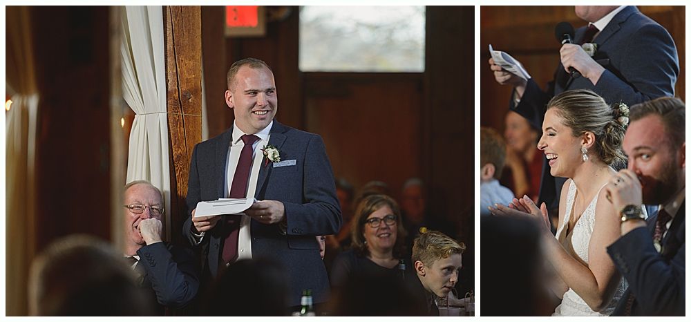 A man in a suit gives a speech at a wedding. The bride and groom laugh while listening.
