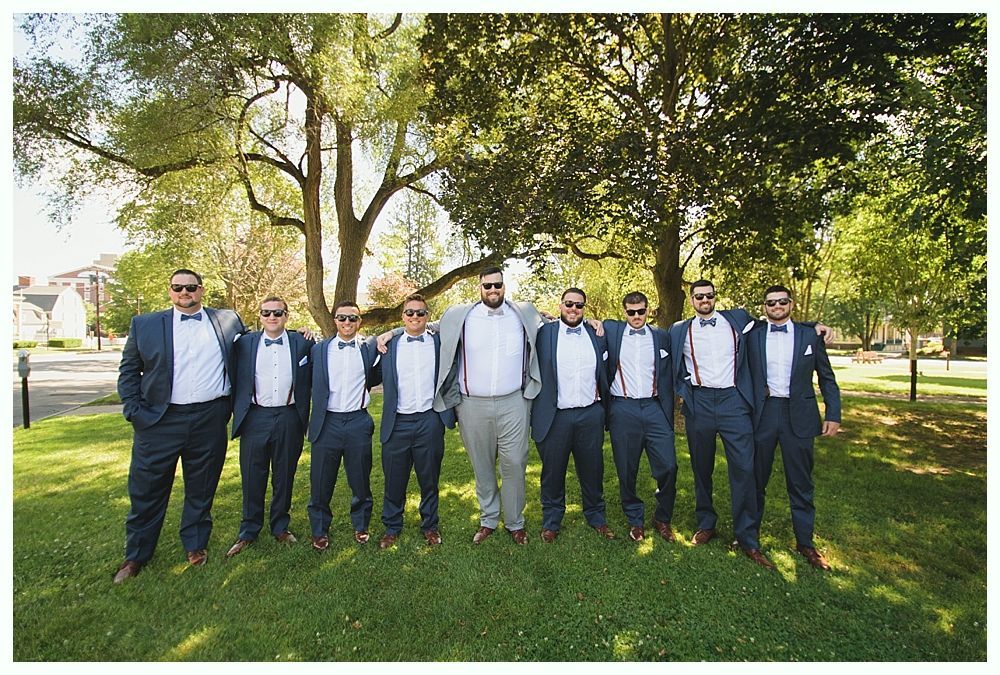 Group of men in suits posing outside.