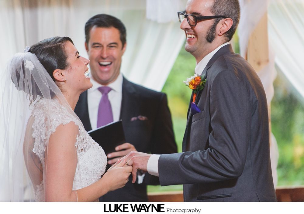 Bride and groom embrace outdoors near a tree with yellow leaves.
