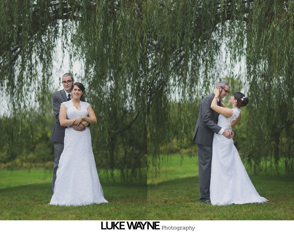 Couple dances at a wedding reception; guests watch. Black and white.