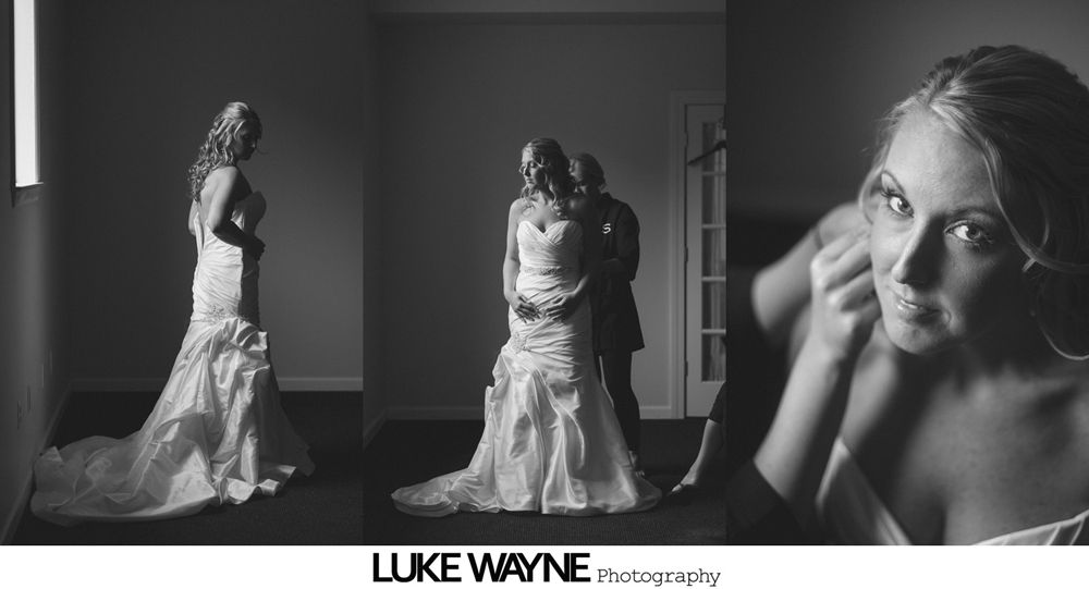 Bride in a wedding dress. Two assistants help her. Black and white, indoor.
