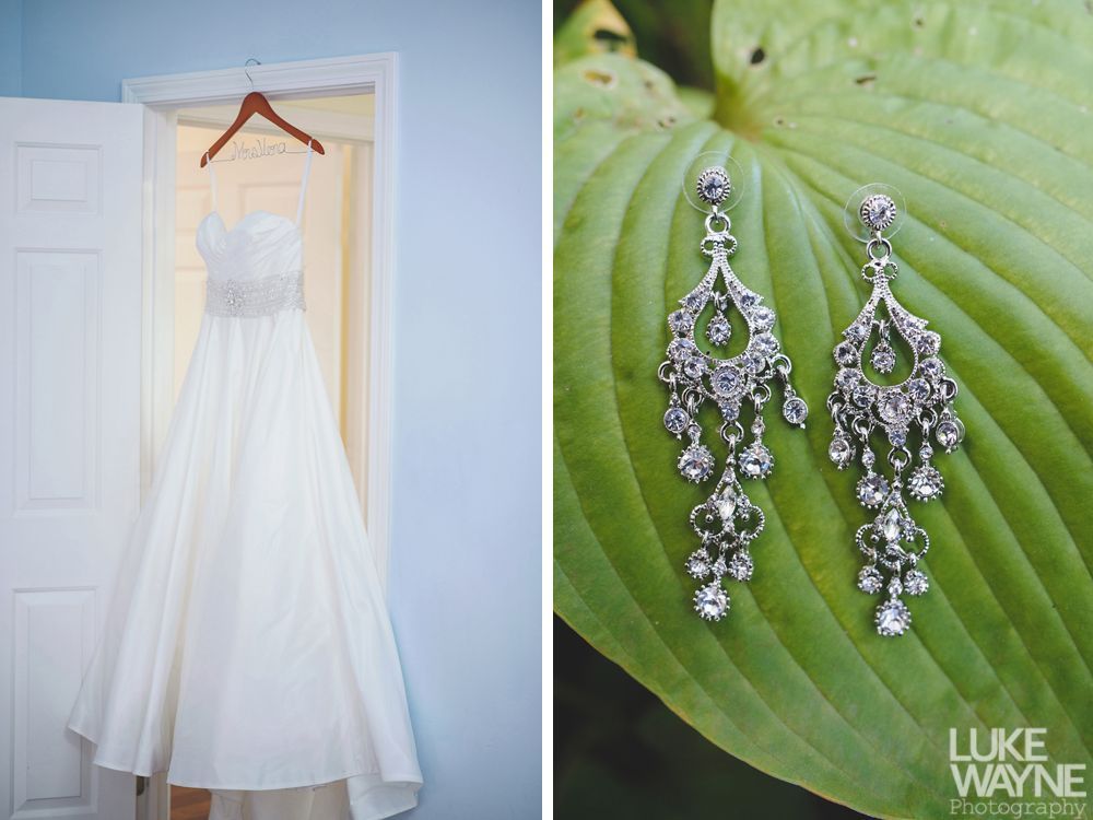 Wedding rings, bouquet, and embellished shoes arranged on dark blue fabric.