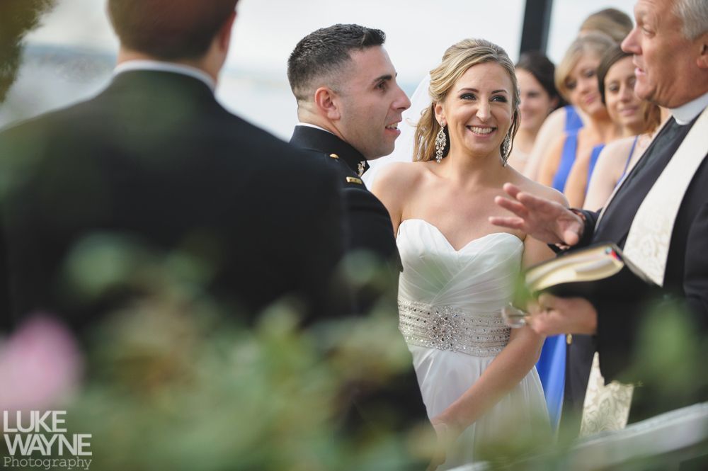 Wedding party in purple and gray outfits posing outdoors in front of city buildings.