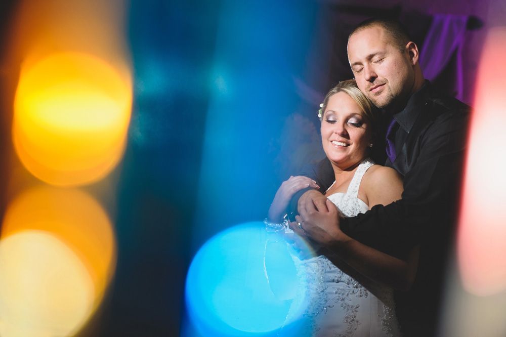 Wedding reception details: cake, flowers, wine, purple and white decor.