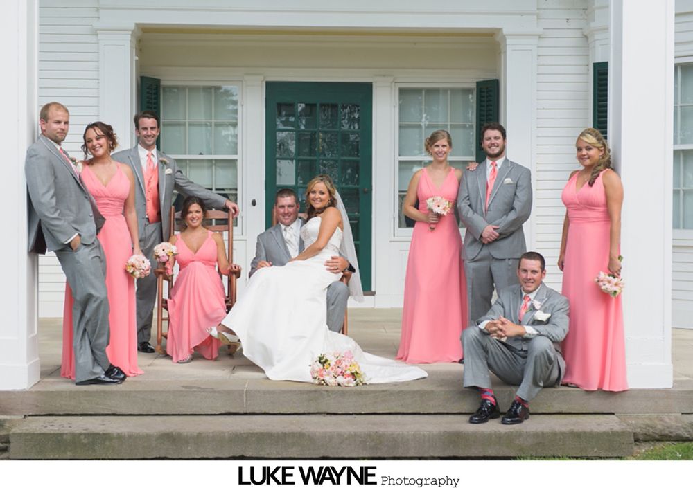 Couple kissing at their wedding ceremony inside a glass-roofed structure, surrounded by guests.