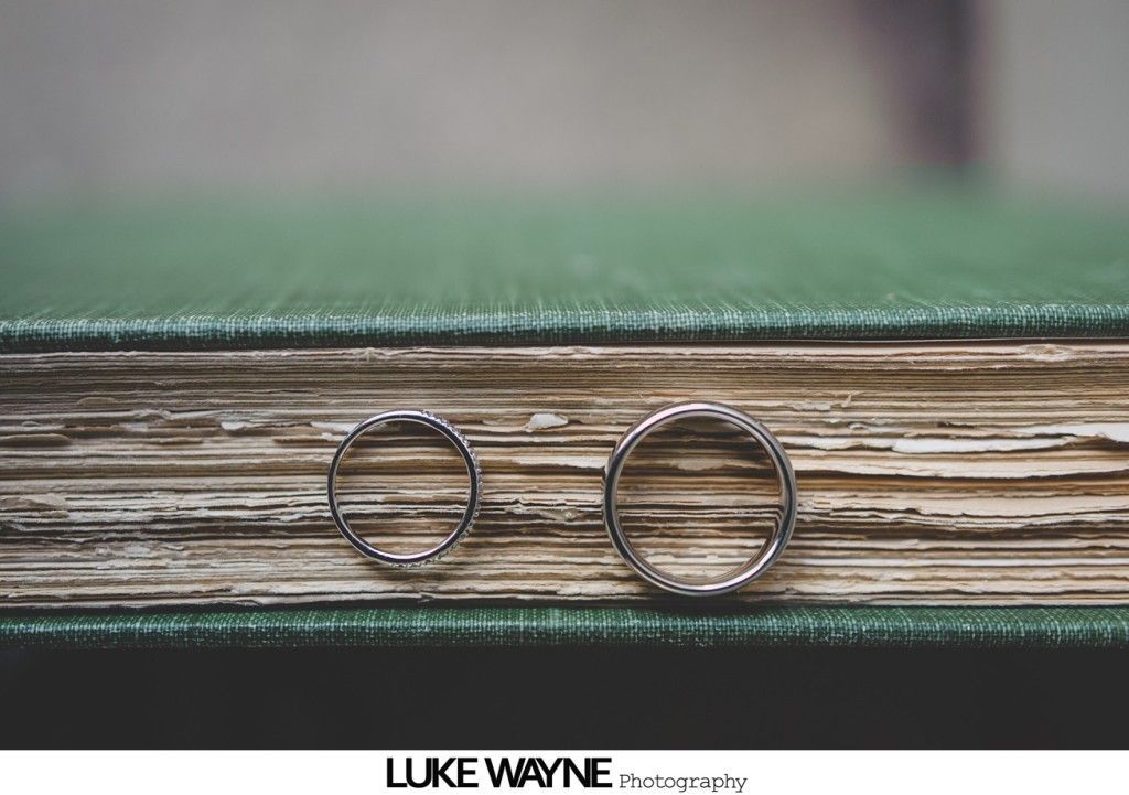 Two wedding rings on a weathered green book.