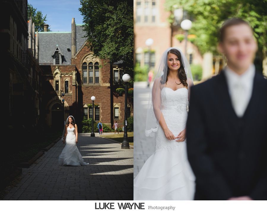 Bride in white gown, veil, standing on a brick path, facing groom in a dark suit, outdoor setting.