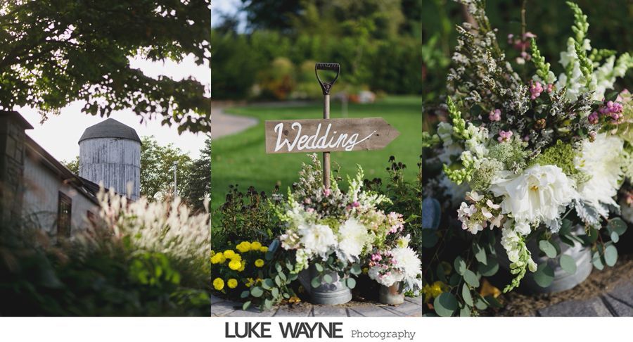 Rustic wedding scene with flowers, sign, and barn.