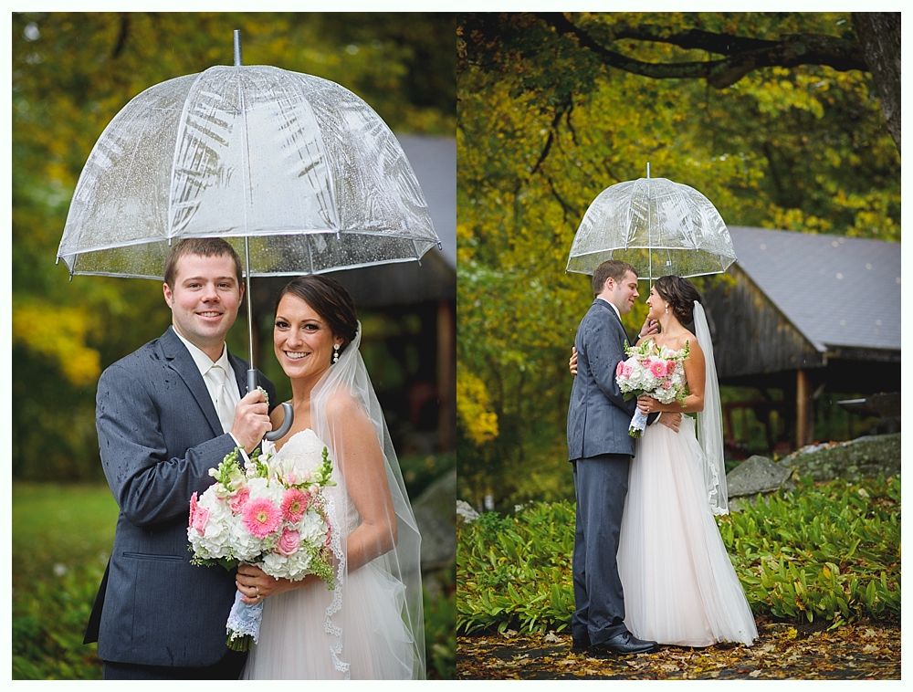 Wedding couple under a clear umbrella, posing outdoors. The bride holds a bouquet.