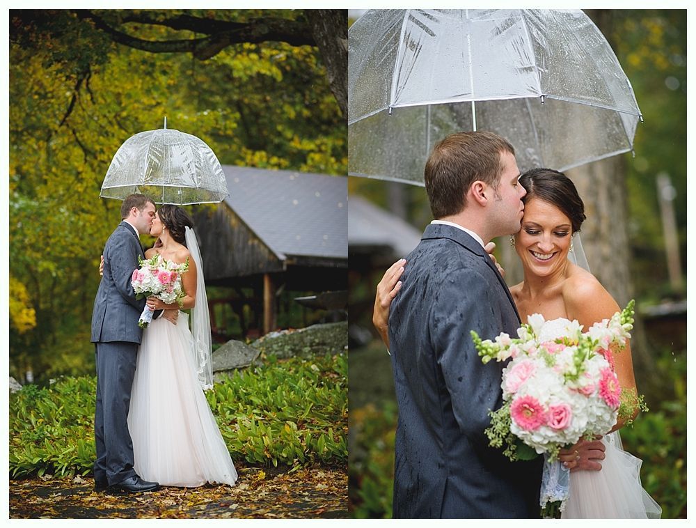 Bride and groom under clear umbrella, kissing, holding flowers, outdoor wedding.
