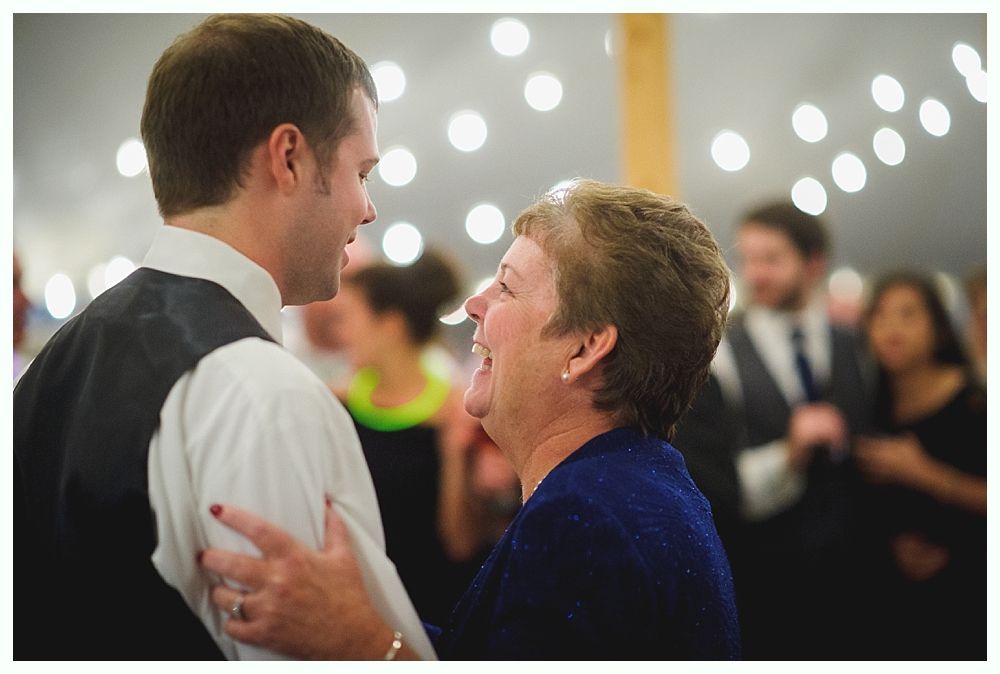 Man dancing with a smiling woman under string lights at a party.