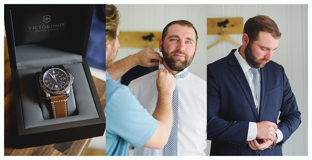 A man with a beard receives help adjusting his suit and tie, alongside a watch box containing a wristwatch.